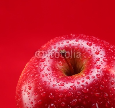 Red apple with leaf on a red background
