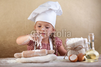 Little girl stretching the cookie dough