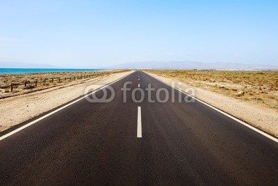Straight road in desertic seascape. Andalusia.