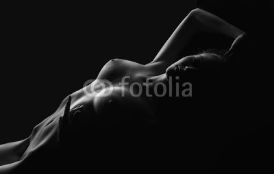 Young woman lay in dark - touch herself in desire