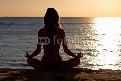 Woman in yoga lotus meditation front to seaside