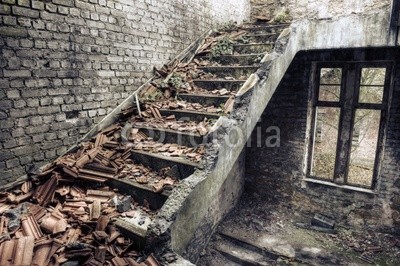 Collapsed roof tiles on a staircase in a derelict building