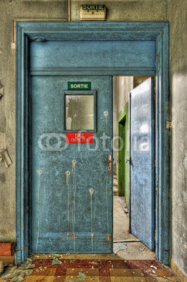 Blue emergency wooden fire door in an abandoned hospital