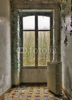 Window, radiator and stained peeling wall in an abandoned room