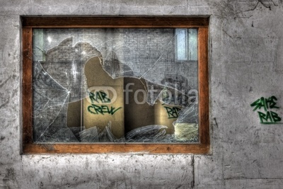 Broken window pane in derelict industrial factory building