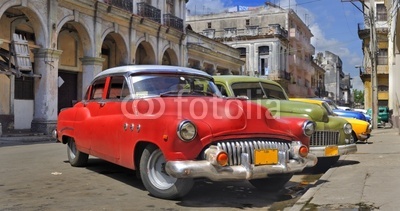 Havana street with colorful old cars in a raw