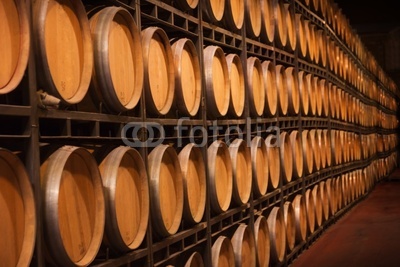 Endless pile of wine barrels in an aging cellar