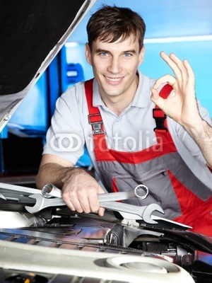 Master mechanic is satisfied with his job in a garage